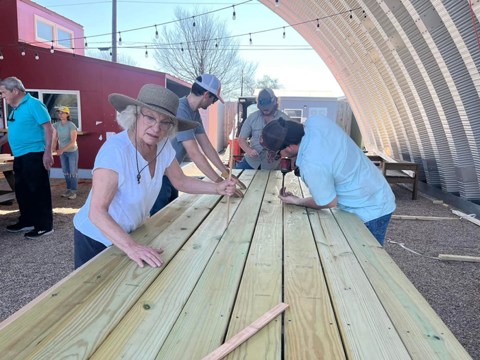 Volunteers building wooden deck at The Other Ones Foundation community site in Austin, Texas