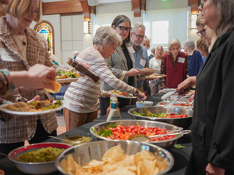 Parishioners of all generations serving themselves buffet meal at Good Shepherd Episcopal Church fellowship event in Austin Texas