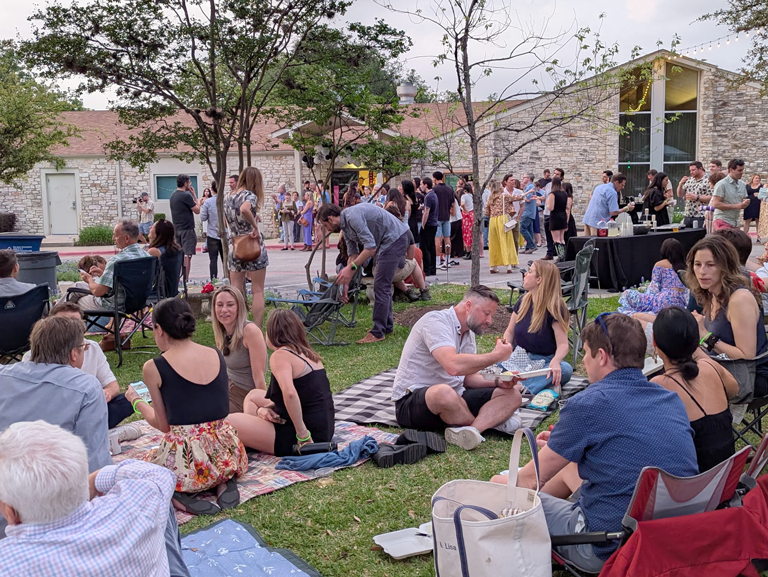 Community members gathered outdoors for Hillside Under the Stars fundraiser at Hillside Early Childhood Center in Austin