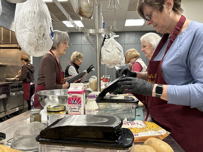St Brigid’s Guild volunteers preparing meals in church kitchen at Good Shepherd Episcopal Church in Austin Texas