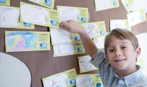 Young child places a pledge card on a stewardship display at Good Shepherd Episcopal Church in Austin, Texas.
