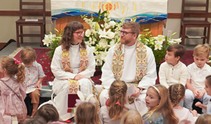 Episcopal clergy sit with young children during a family worship service at Good Shepherd Episcopal Church in Austin, Texas.