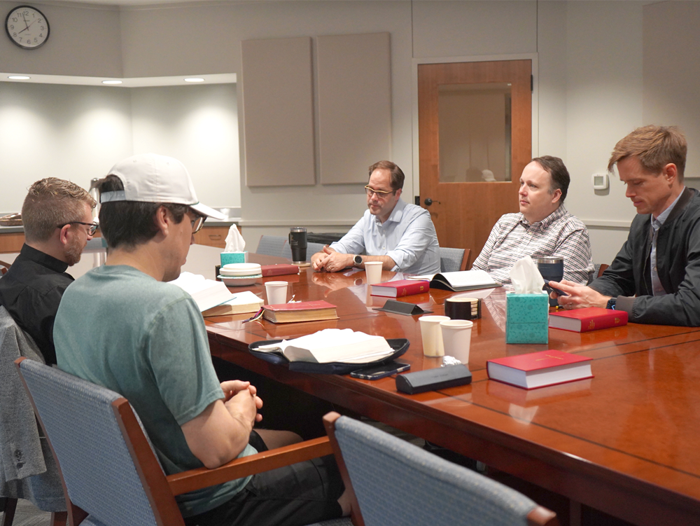 Fathers gather around a table with Bibles and prayer books for a dads Bible study at Good Shepherd Episcopal Church in Austin, Texas.